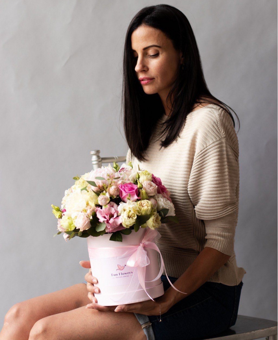 Flowers in a hatbox with roses and lisianthus in addition to peony varieties of roses